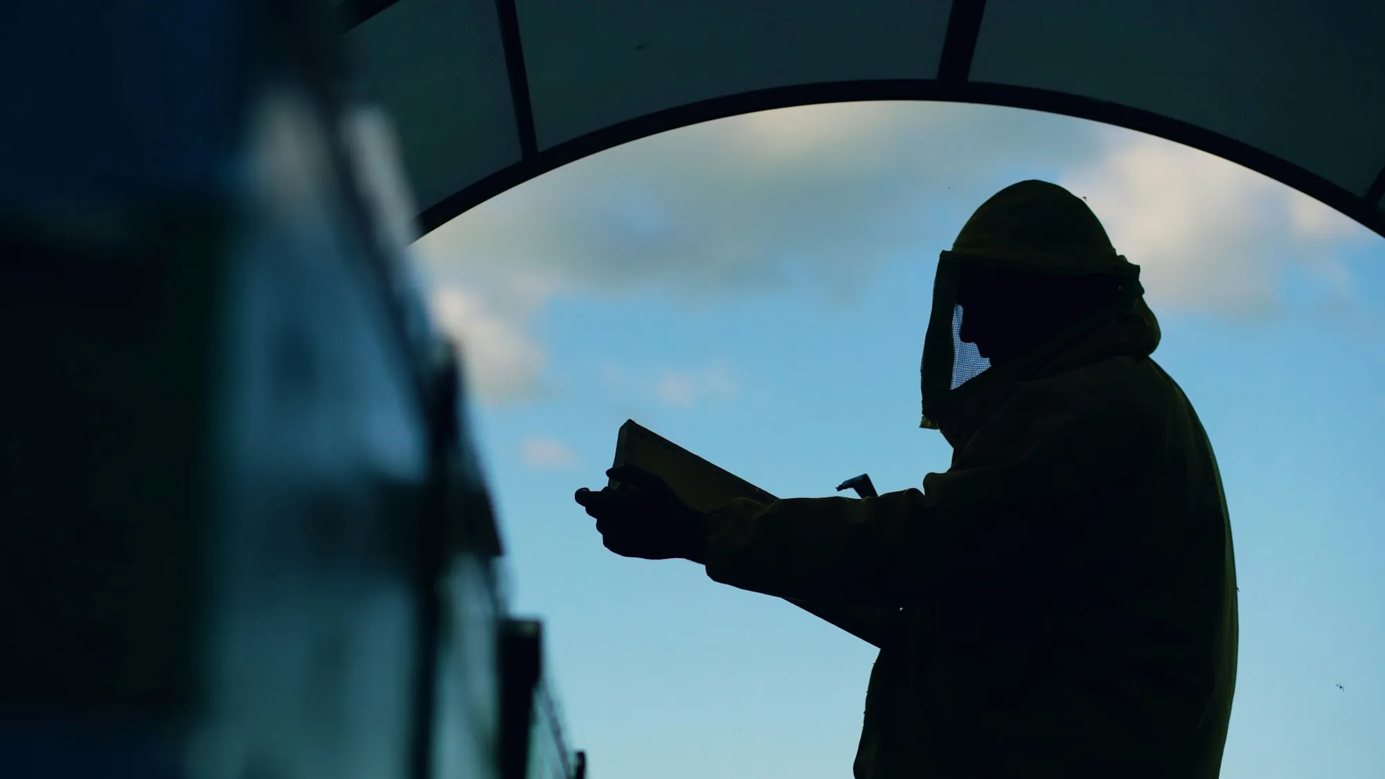 Silhouette of a man in a hard hat reading a clipboard