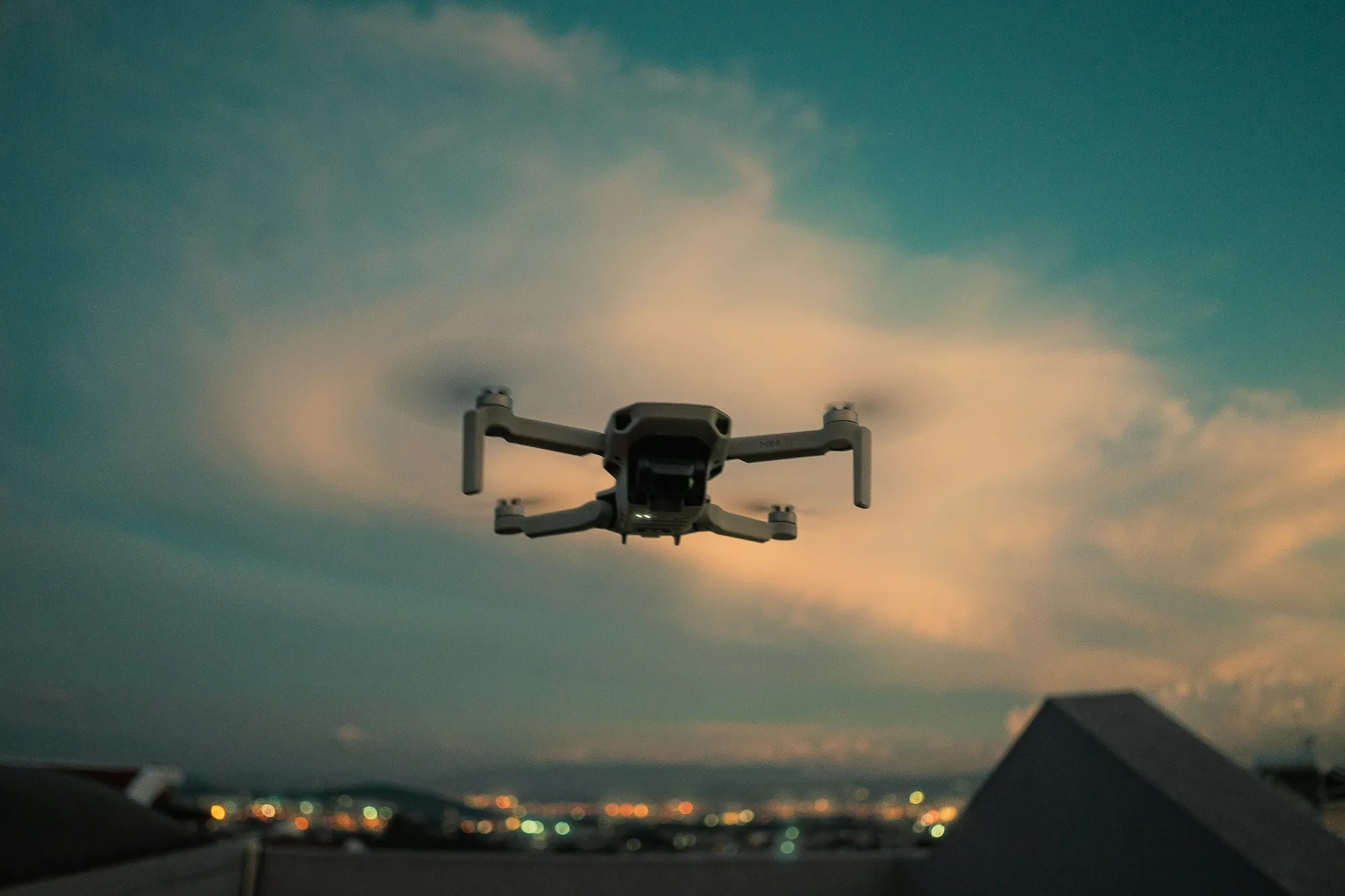 Small drone hovering against a cloudy evening sky