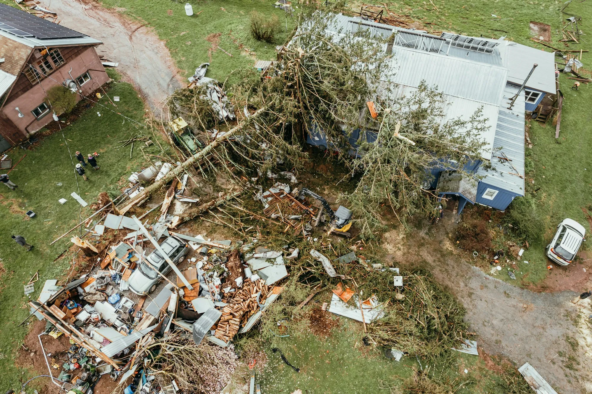 Aerial view of storm debris and downed trees around houses